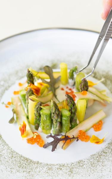 La recette Duo d’asperges vertes et son tarama maison dressée dans une assiette par Maxime Pujol, chef du restaurant Bergamote.